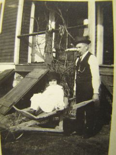 Small Antique Photo Girl Rides Wheelbarrow w/ Pipe Man