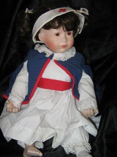 KATHY HIPPENSTEEL PORCELAIN DOLL WITH RED CROSS HAT AND CAPE
